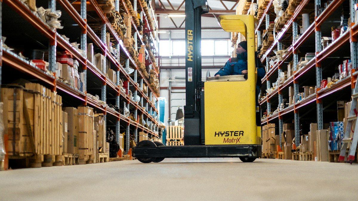 Warehouse aisle with a forklift, representing operational processes that can be automated