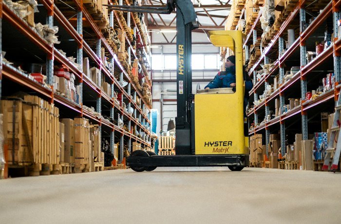 Warehouse aisle with a forklift, representing logistics dispatch automation